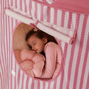 A young girl sleeps peacefully inside a Tiny Land® Kids Tent – Indoor Tent for Toddlers, cuddling a plush flower pillow and a furry cushion.|Pink