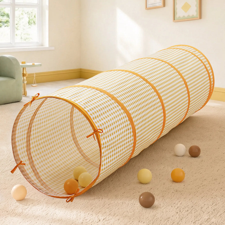 A yellow gingham Tiny Land® Adventure Play Tunnel rests on a carpet scattered with several play balls.|Yellow