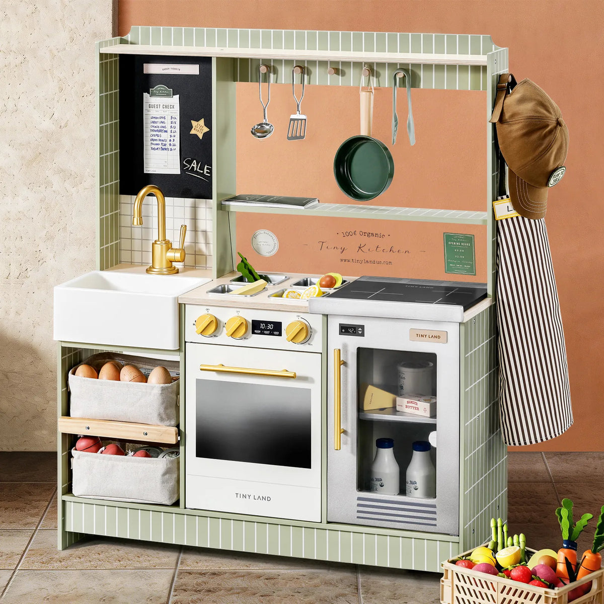 The Tiny Land® BistroSwitch Play Kitchen by Tiny Land features a sink, stove, oven, refrigerator with milk bottles, and shelves. Comes with play food, accessories, plus a hat and striped apron hanging on the side for pretend chef fun.|Green