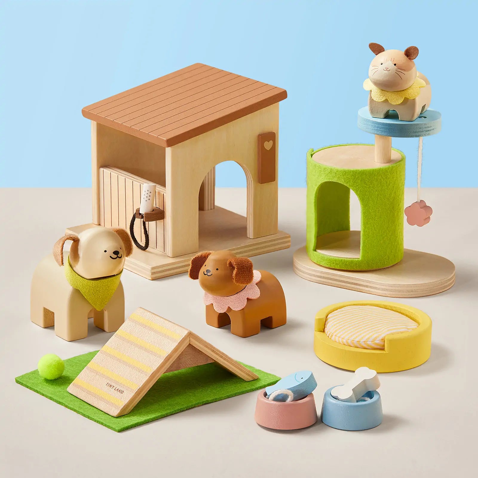 The Early Bird Eggs-Tiny Land® Happy Urban Paws by Test features a wooden pet playset with pretend dog, cat, mini pet house, beds, bowls, scratch post, and ramp—arranged on a light surface with a blue background.