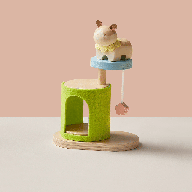 The Early Bird Eggs-Tiny Land® Happy Urban Paws by Test is a small wooden pet playset with a cute animal figure, green felt arch, hanging pink flower, and light wood base, shown on a beige and white background.