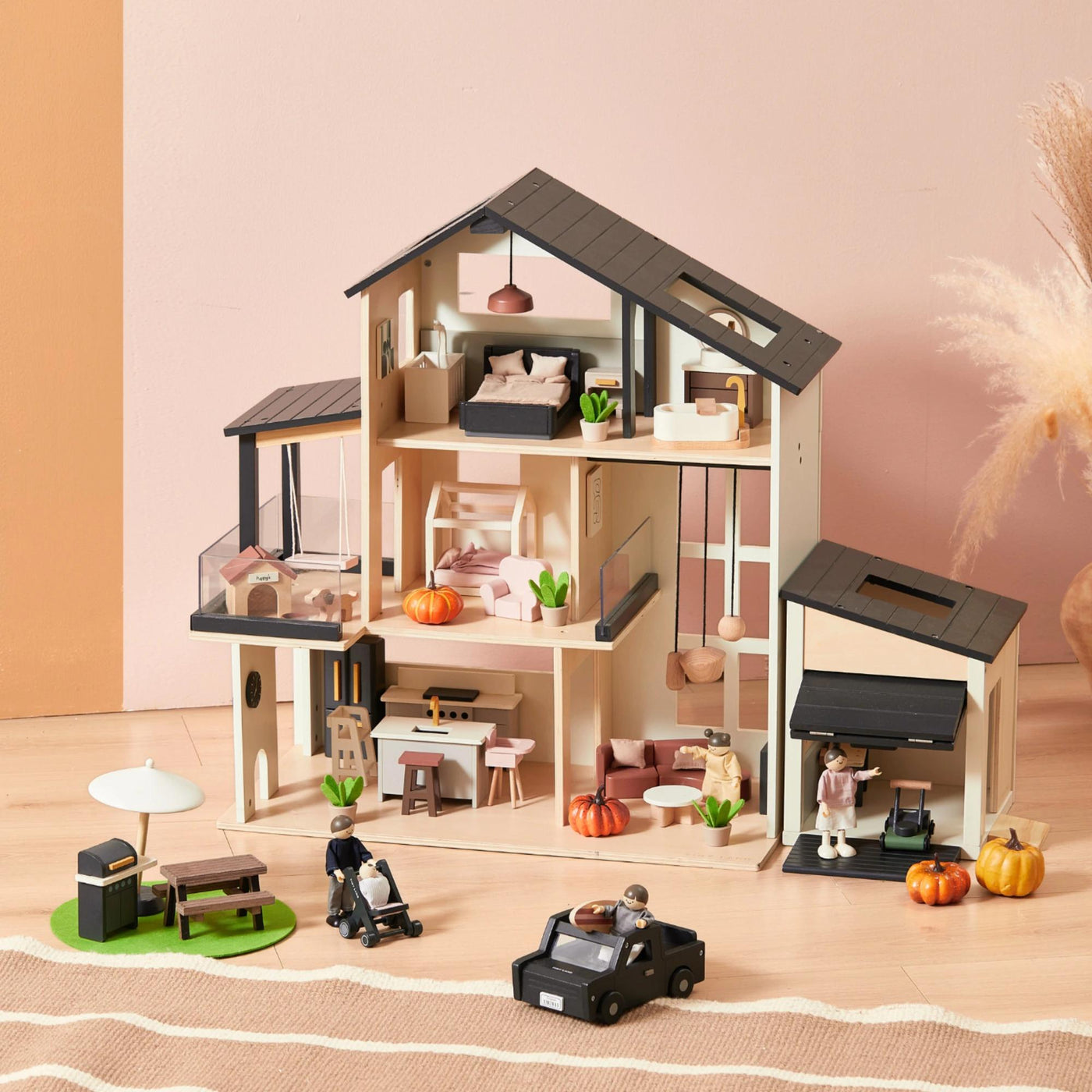 The Tiny Land Sweet Family Gift Set includes a modern black dollhouse, garage, extra dolls, and miniature furniture—complete with multiple rooms and patio for imaginative play.