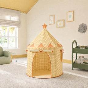 The Tiny Land® Kids Tent – Indoor Tent for Toddlers by Tiny Land INC, featuring yellow and white gingham and a star on top, stands on a light carpet in a sunny kids' room with a green couch, toy cart, and framed wall art nearby.
