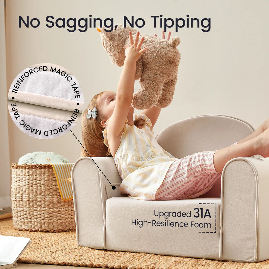 A young child sits on the Tiny Land® GentleSnug Kid Chair in beige, lifting a stuffed animal overhead. Highlighted features include No Sagging, No Tipping, Reinforced Magic Tape, and Upgraded 31A High-Resilience Foam—making this Tiny Land chair the perfect comfortable playroom furniture for your little one.|Beige