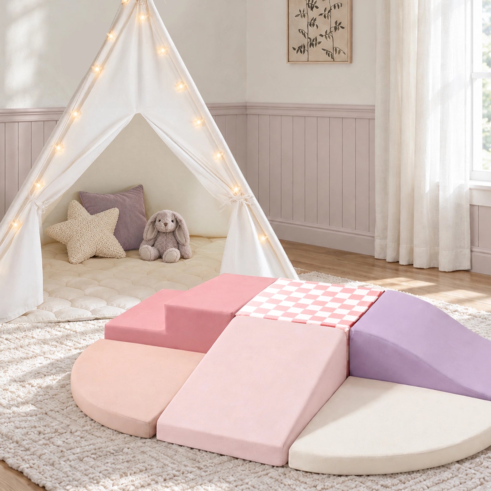 A Tiny Land® Teepee Tent decorated with fairy lights stands next to a set of Violet PlayNest Climbing Blocks arranged in a circle on a rug to create a cozy play corner.